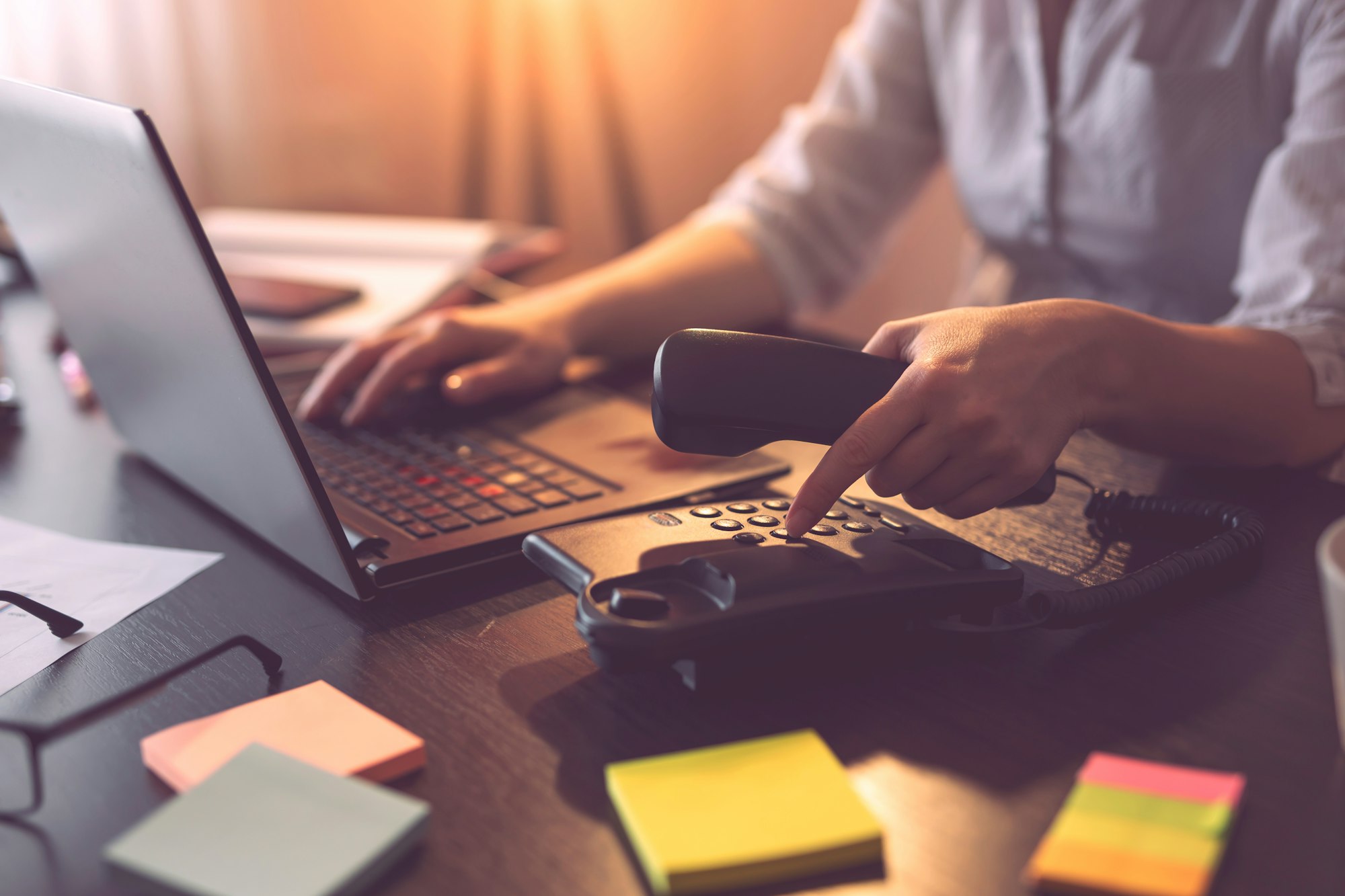 Woman dialing a number on a telephone